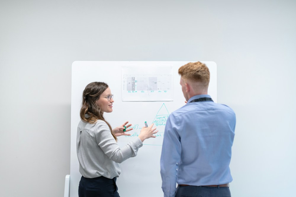 Two colleagues planning at a whiteboard