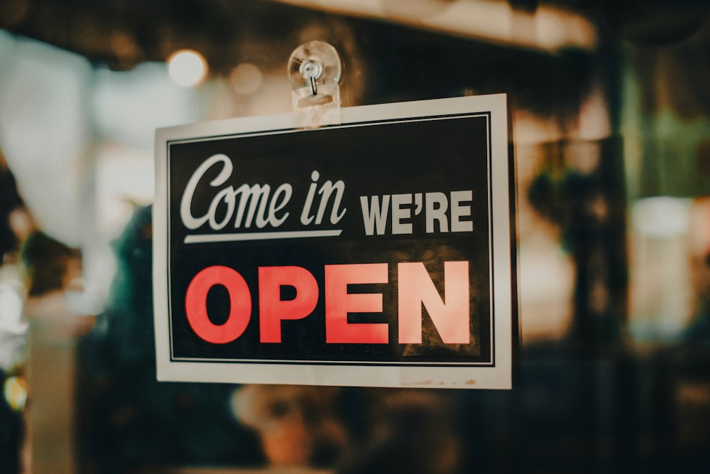 A 'Come in, we're open' sign in a shop window