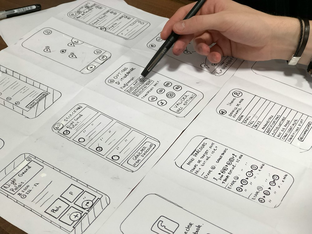 A designer sketching website wireframes on paper